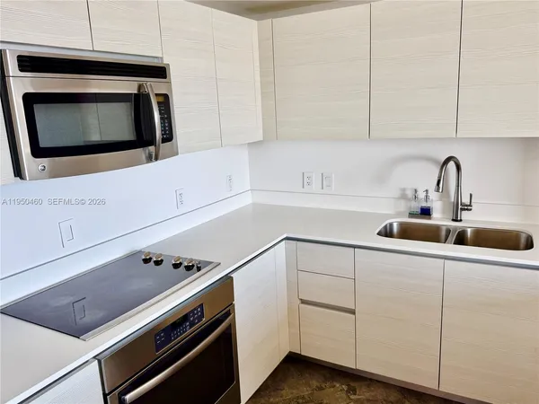 a kitchen with stainless steel appliances white cabinets and a stove a sink