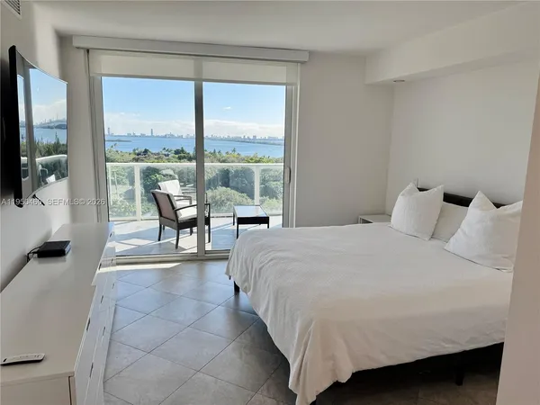 a bedroom with a bed and a flat tv screen next to a window