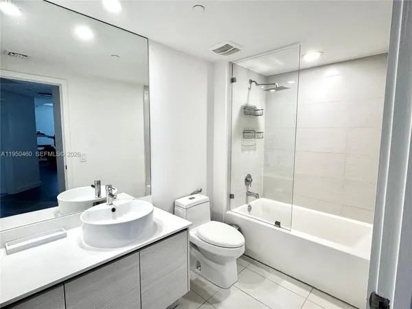 a bathroom with a sink toilet tub and shower