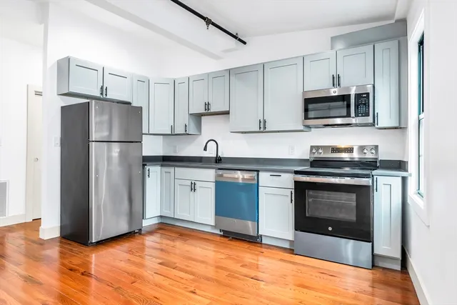 a kitchen with stainless steel appliances granite countertop a stove a refrigerator and a microwave