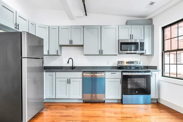 a kitchen with granite countertop a refrigerator stove and microwave