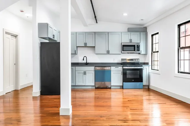 a kitchen with stainless steel appliances granite countertop a stove a sink and a refrigerator