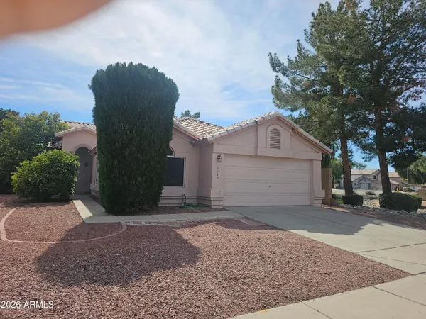 a view of a house with a yard and large tree