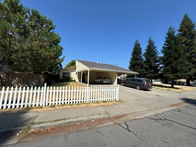 a view of a house with a wooden fence