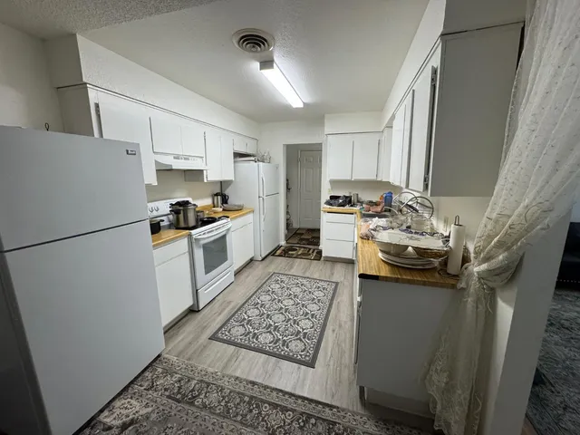 a kitchen with stainless steel appliances granite countertop a refrigerator stove a sink dishwasher and a stove