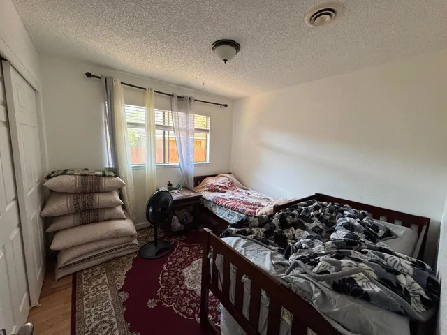 a bedroom with bed couch and window