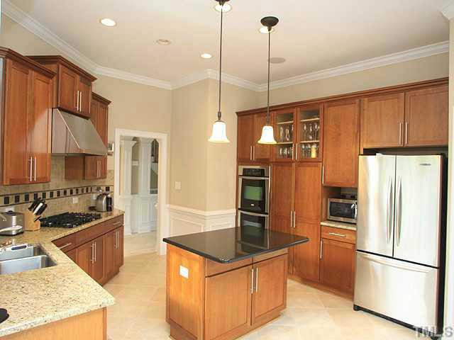 2259 Clayette Court Raleigh, NC 27612 - Photo 10 of 25 Amazing Chef's Kitchen with stainless steel hood over gas cook top, granite countertops, double oven, and beautiful cherry cabinets.Gorgeous tile flooring. Lighting fixtures and recessed lighting. Stainless steel appliances, center island, storage space. Kitchen
