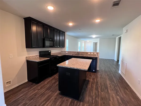 a kitchen with wooden floors sink and cabinets