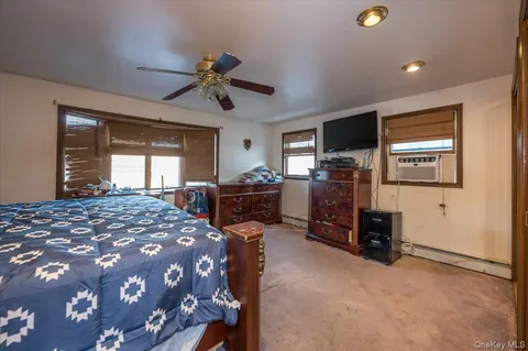 a bedroom with a bed and dresser with chair
