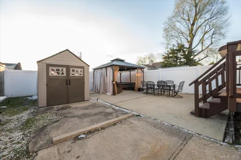 a view of a house with a wooden bench next to a road