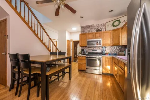 a kitchen with granite countertop wooden floors stainless steel appliances and a window