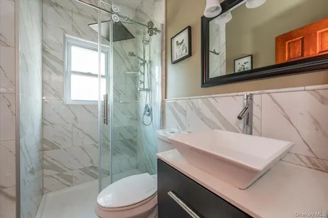 a bathroom with a sink a toilet and shower