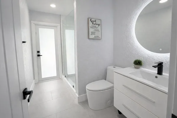 a white toilet sitting next to a bathroom sink