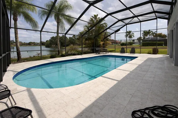 a view of a swimming pool with a chair and tables in the back yard