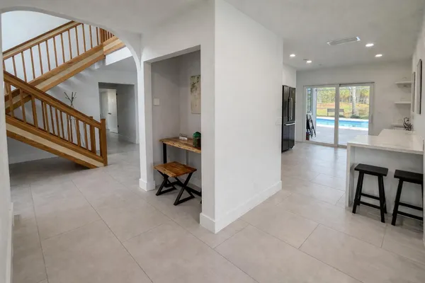 a view of a hallway with workspace and a livingroom with furniture