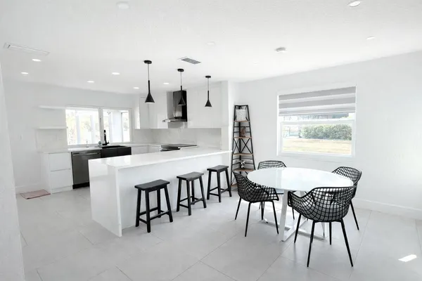 a dining room with kitchen island a table and chairs