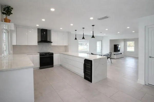 a large kitchen with a large counter top stainless steel appliances and cabinets