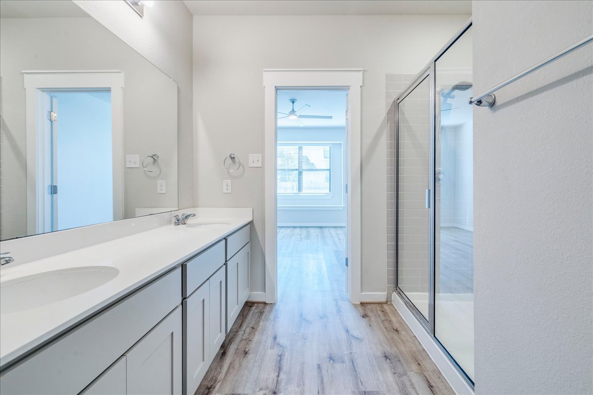 144 Threshing Road, Unit A Buda, TX 78610 - Photo 17 of 35 Primary bathroom offers double sinks, large walk-in shower and a walk-in closet.