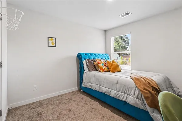 a bed sitting in a bedroom next to a window