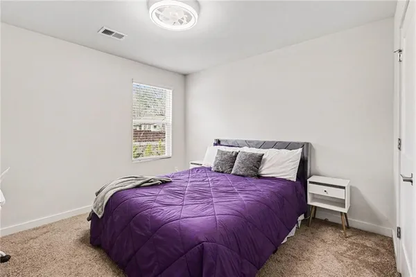 a bed sitting in a bedroom next to a window