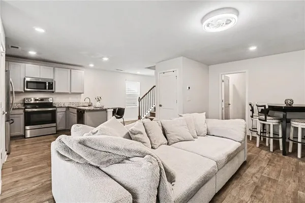 a living room with furniture and a wooden floor