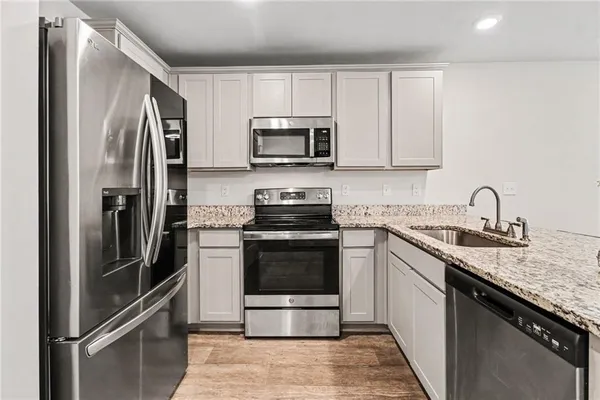 a kitchen with stainless steel appliances granite countertop a refrigerator sink and stove