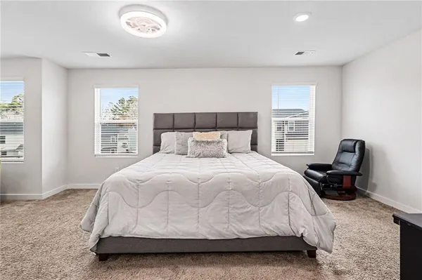 a bedroom with a bed chair and a window
