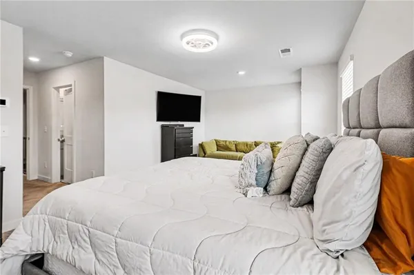 a bedroom with a bed and a flat screen tv