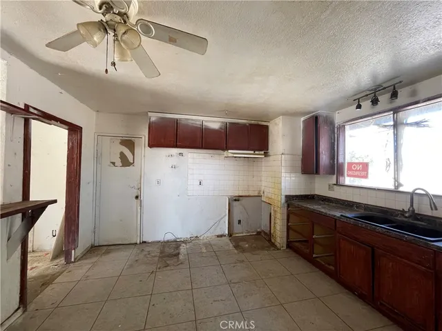 a kitchen with stainless steel appliances a sink a stove a refrigerator cabinets and a window