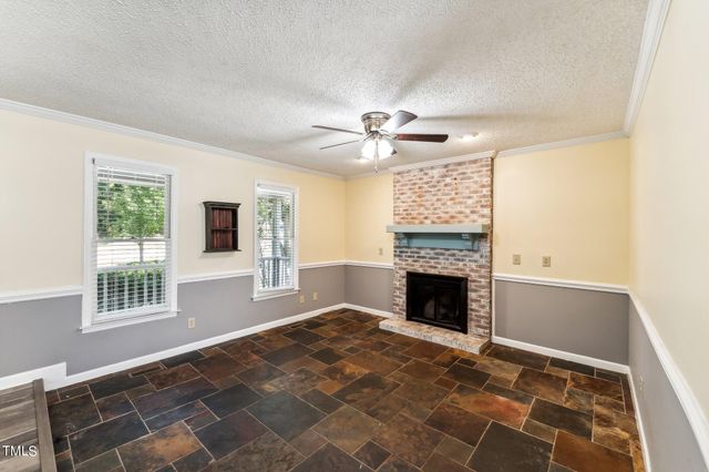 a view of an empty room with window and fire place