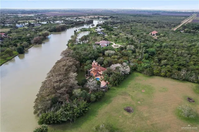 an aerial view of green landscape with trees houses and lake view