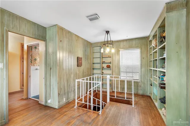 a view of a hallway with wooden floor and windows