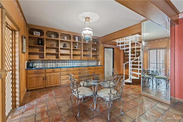 a dining room with chandelier fan and wooden floor