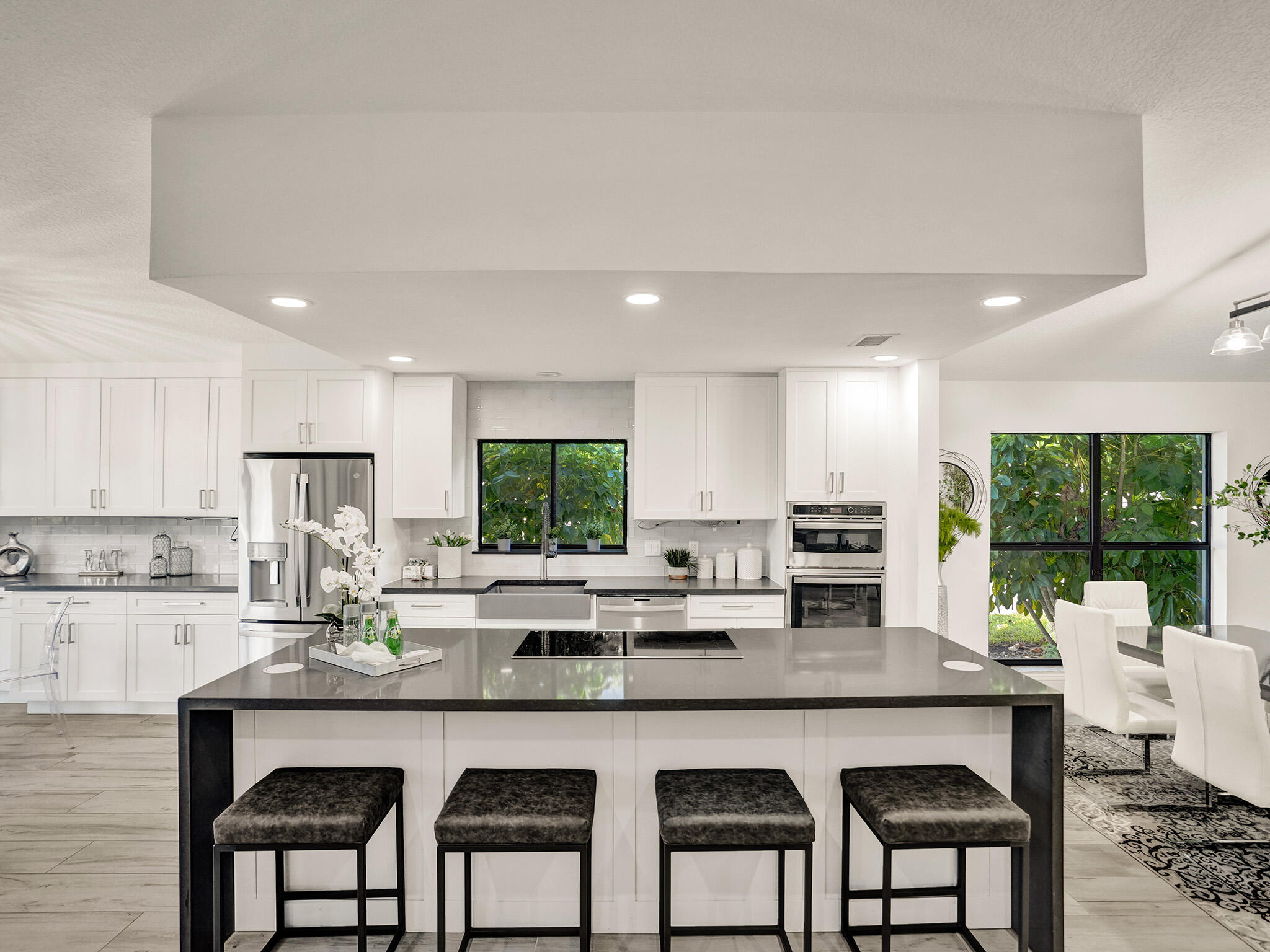 10698 Crystal Lake Drive Boca Raton, FL 33428 - Photo 12 of 48 a kitchen with a table chairs microwave and cabinets