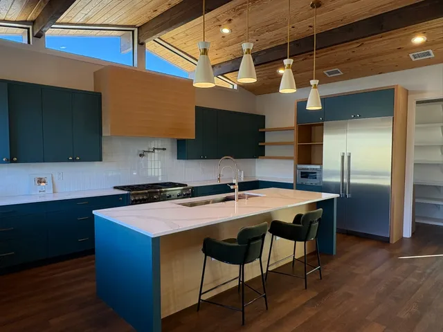 a kitchen with a stove a sink and a granite counter top