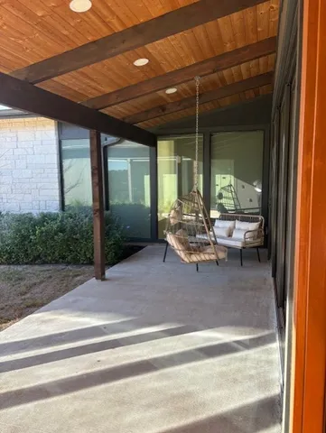 a view of an empty room with wooden floor and a ceiling fan