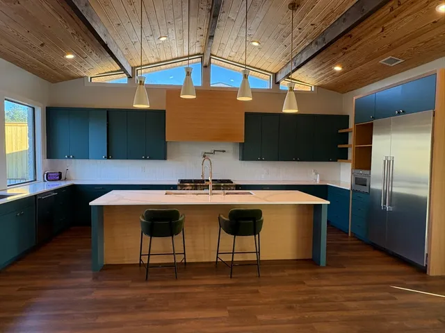 a kitchen with stainless steel appliances granite countertop a sink a stove and a wooden floors