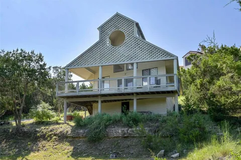 a view of house with river and trees in the background