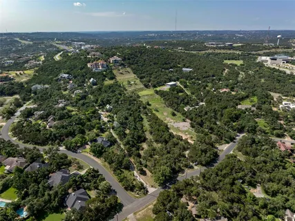 an aerial view of residential houses with outdoor space and trees