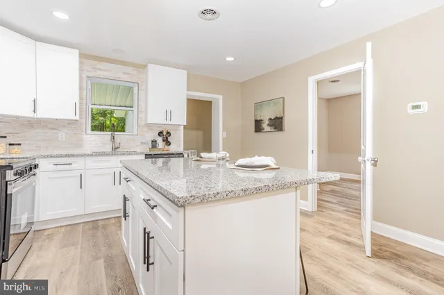 a kitchen with granite countertop kitchen island a sink appliances and cabinets