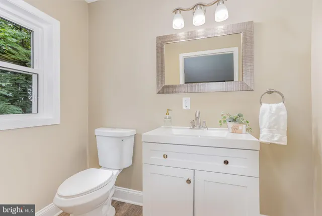 a bathroom with a toilet sink vanity and mirror