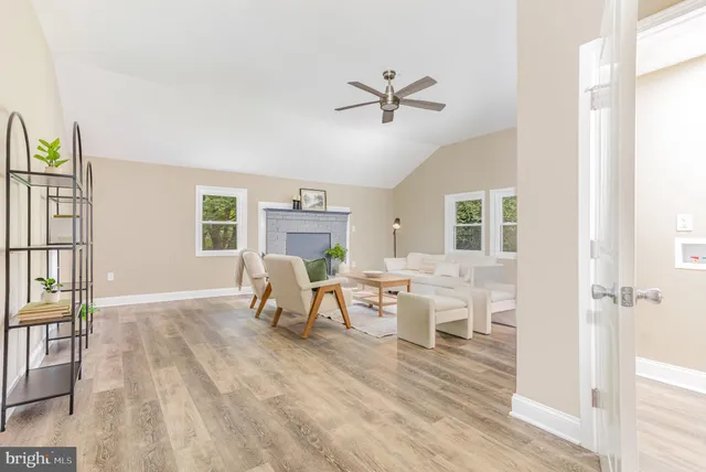a living room with furniture a window and a ceiling fan