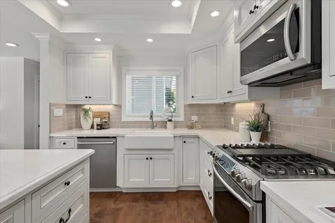 a kitchen with stainless steel appliances granite countertop a stove a sink and a microwave