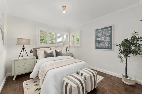 a bedroom with a bed and a potted plant