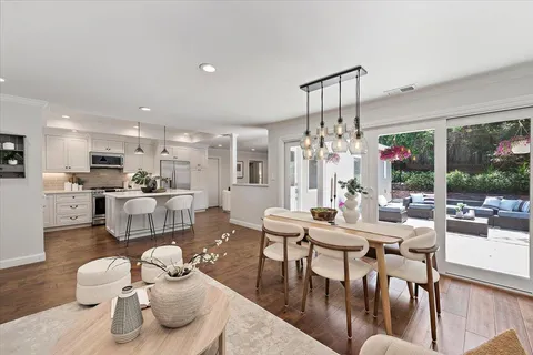 a living room with furniture kitchen view and a chandelier