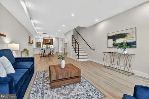 a living room with furniture and a wooden floor