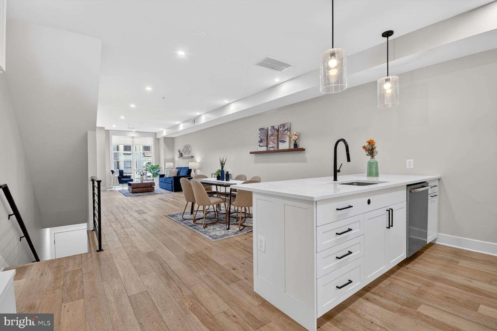 3532 1/2 13th Street Northwest, Unit 2 Washington, DC 20010 - Photo 11 of 38 a kitchen with stainless steel appliances a dining table chairs and wooden floor