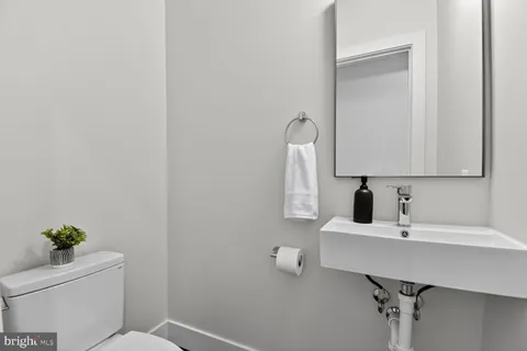 a bathroom with a sink a toilet and a mirror