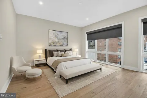 a spacious bedroom with a bed and wooden floor