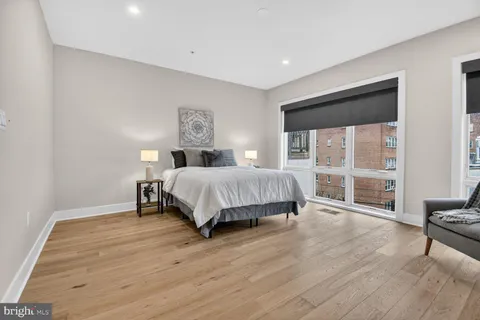 a bedroom with a bed a table and painting on the wall